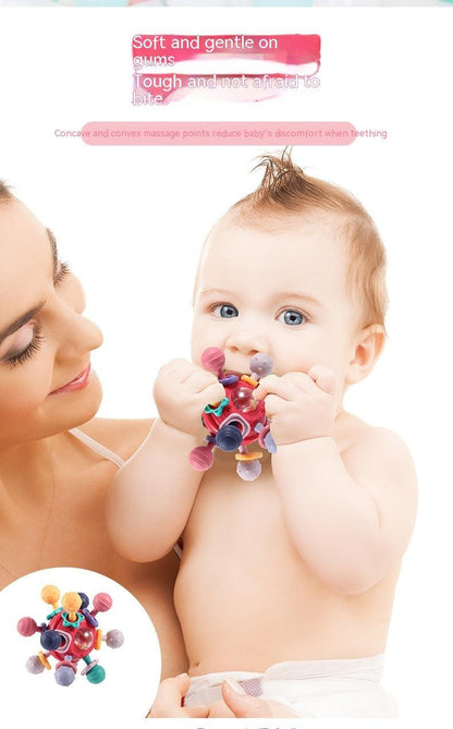 Baby holding colorful Manhattan Finger Ball Rattle Toy for sensory play.