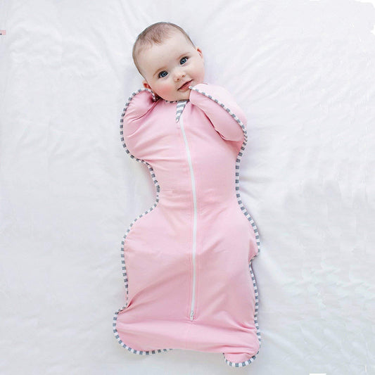 Baby in pink cotton swaddling sleeping bag with zipper, anti-kick quilt design.