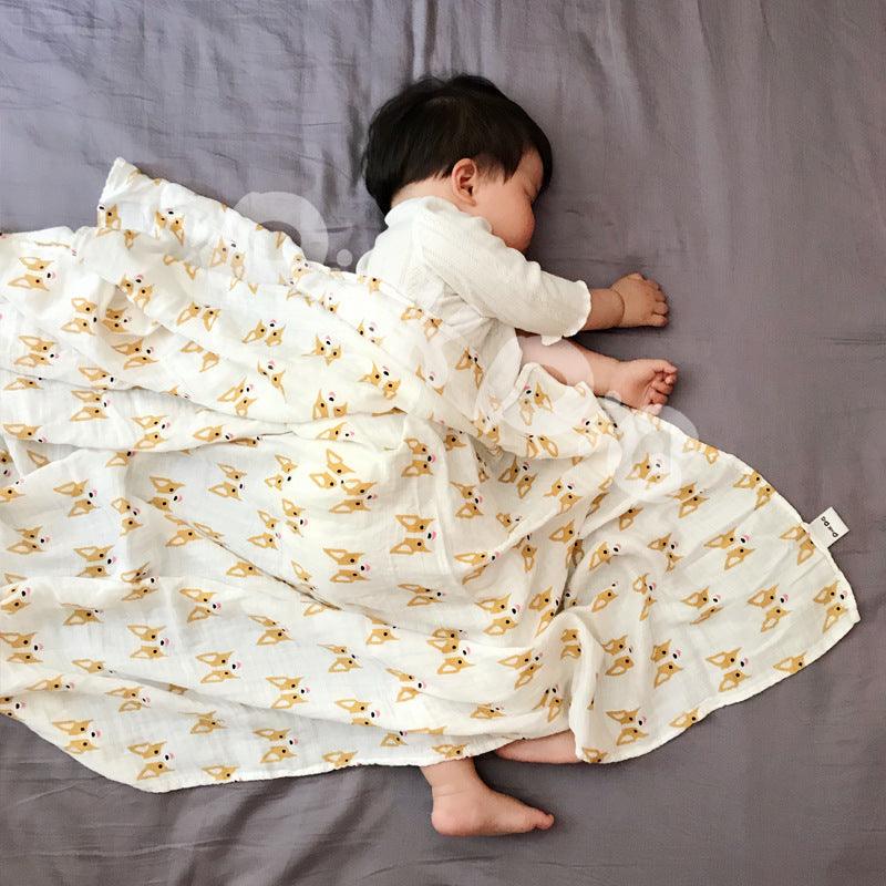 Sleeping baby in Cozy Cartoon Baby Wraps on grey sheet.