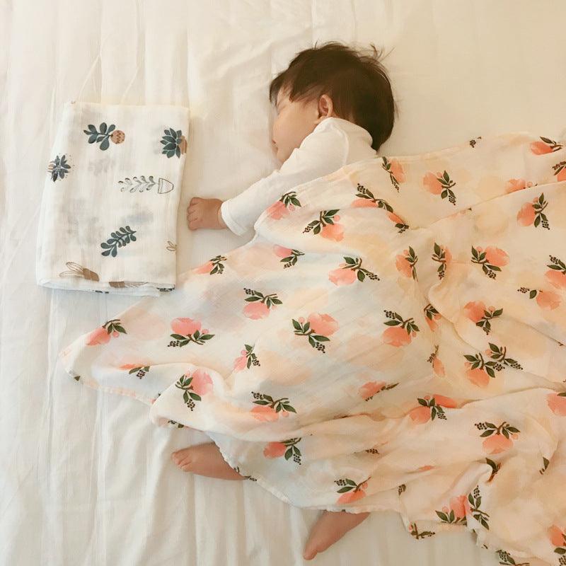 Baby wrapped in a floral cartoon wrap on a bed.