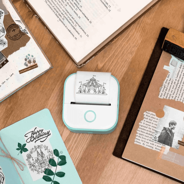 Portable PocketPrint device on a desk surrounded by printed notes and books.