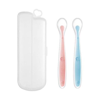 Silicone baby feeding spoons in pink and blue with a clear carrying case.