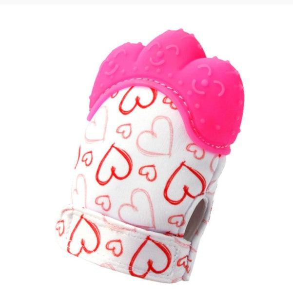 Silicone baby chew toy with pink teething surface and heart-patterned fabric.