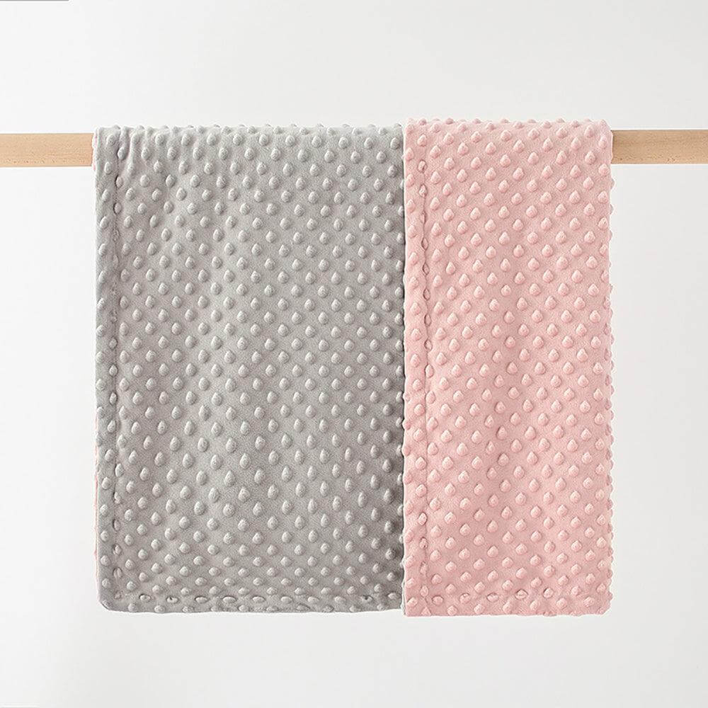 Ultra Soft Dotted Baby Blanket in grey and pink hanging on a rod.